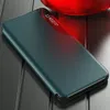 A teal flip case for a smartphone is shown on a dark, reflective surface, with a red object in the background. Produktbild-Vorschau