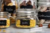A collection of glass jars filled with food items, labeled with chalkboards. Produktbild-Vorschau