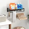 A laundry room shelf with laundry supplies, a towel, and hangers. Produktbild-Vorschau