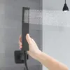 A hand holding a black shower head with water spraying from it. Podgląd zdjęcia produktu