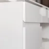 A close-up view of the corner of a white desk with drawers. Produktbild-Vorschau