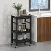 A black kitchen cart with a stainless steel top is shown next to a kitchen counter and sink. Náhled obrázku produktu