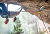 Edelrid Ohmega Bremsassistent in gelb an Karabiner an Felsüberhang mit Kletterseil und Kletterer mit Helm Podgląd zdjęcia produktu