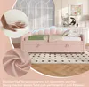 A pink upholstered daybed with a scalloped headboard featuring LED lighting, shown in a bedroom setting with decorative pillows and a rug. Produktbild-Vorschau