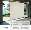 A beige retractable awning is shown extended in front of a glass sliding door, overlooking a swimming pool and palm trees. Náhled obrázku produktu