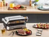 A Tefal OptiGrill is shown on a kitchen counter with food and cooking ingredients. Produktbild-Vorschau
