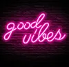A pink neon sign that says "Good Vibes" is mounted on a dark brick wall. Produktbild-Vorschau