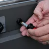A person's hands are inserting a battery into a device. Produktbild-Vorschau