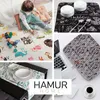 A collage of four images showing different home and baby products, including a baby playing on a mat, kitchen accessories, a laptop sleeve, and a dining table setting. Produktbild-Vorschau