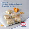 Several slices of cake topped with cream and fruit are arranged on a white surface, with whole and sliced mandarins nearby. Anteprima dell’immagine prodotto