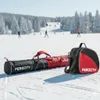 A ski bag and ski boot bag are placed on a snowy ski slope with skiers in the background. Produktbild-Vorschau