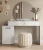 A white vanity table with a round mirror and a beige stool in front of it. Produktbild-Vorschau