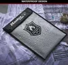 A Master Lock fire-resistant document bag is shown covered in water droplets, resting on papers and a checkered cloth. Voir les images du produit