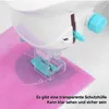 Close-up of a toy sewing machine with a needle and thread stitching on pink fabric. Produktbild-Vorschau