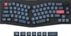 A split ergonomic keyboard with dark gray keys and red accent keys, shown from a top-down perspective against a black background. Below the keyboard are individual keycaps. Anteprima dell’immagine prodotto