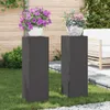 Two black plant stands with potted plants on top, placed on a lawn in a garden setting. Podgląd zdjęcia produktu