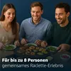 Three people are enjoying a raclette meal together at a table. Produktbild-Vorschau