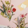 A flat lay of artificial flowers and a greeting card on a pink background. Anteprima dell’immagine prodotto