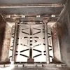 Close-up view of the inside of a grill, showing two metal heat deflectors and two burner tubes. Podgląd zdjęcia produktu