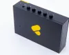 A black portable cassette player with a yellow logo and yellow accents on top, set against a white background. Náhled obrázku produktu