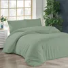 A neatly made bed with light green bedding is shown in a room with a large window and a plant. Produktbild-Vorschau