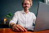 A man is using a laptop at a desk, inserting a USB drive. Voir les images du produit