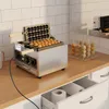 A waffle maker is shown on a kitchen counter, with waffles being made and a rack of finished waffle pops nearby. Podgląd zdjęcia produktu