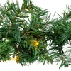 A close-up view of a green artificial Christmas garland with warm white lights woven through it. Anteprima dell’immagine prodotto