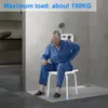 An elderly man sits on a shower stool in a modern bathroom. Produktbild-Vorschau