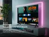 A modern living room setup with a large TV displaying a smart hub interface, surrounded by ambient lighting. Produktbild-Vorschau