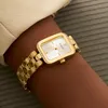 A close-up shot of a gold Guess watch on a person's wrist. Anteprima dell’immagine prodotto