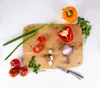 A collection of fresh vegetables and herbs are arranged on a wooden cutting board, ready for preparation. Produktbild-Vorschau