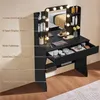 A black vanity table with a mirror and LED lights, featuring various makeup products and storage compartments. Produktbild-Vorschau