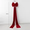 A large red velvet bow with long streamers hangs on a white wall, with dimensions indicated. Podgląd zdjęcia produktu