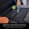 A hand is using a cleaning device on a car seat, with a dog toy and a spill nearby. Podgląd zdjęcia produktu