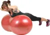 A woman is performing an exercise on a red peanut-shaped fitness ball. Produktbild-Vorschau