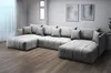 A large, modern U-shaped sectional sofa in a light gray fabric, shown in a well-lit room with wooden floors and minimalist wall art. Náhled obrázku produktu