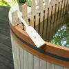 A wooden hot tub with a paddle resting on the edge, set outdoors on a wooden deck. Produktbild-Vorschau