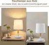 Two images of a white and wood table lamp on a nightstand, one with a cup and plant, the other with just a cup and plant. Náhľad obrázku produktu