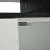 A close-up view of the interior of a white cabinet, showing a push-to-open mechanism attached to the underside of the top panel. Produktbild-Vorschau
