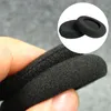 A hand holding black foam ear pads for headphones. Produktbild-Vorschau