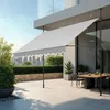 An outdoor patio with a dining set and a retractable awning. Náhled obrázku produktu