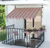A balcony with a striped awning, a chair, a table, and plants. Produktbild-Vorschau