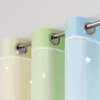 Three eyelet curtains in different gradient colors (yellow, green, blue) hanging on a curtain rod. Produktbild-Vorschau