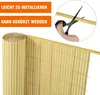 A rolled-up privacy screen and a close-up of a hand cutting it with scissors. Produktbild-Vorschau
