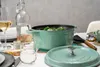 A table setting with a Dutch oven filled with food, wine glasses, and bread. Produktbild-Vorschau
