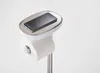 A toilet paper stand with a shelf holding a smartphone. Voir les images du produit