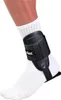 A person's ankle wearing a white sock and a black Mueller ankle brace. Produktbild-Vorschau