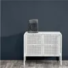 A gray fan heater sits on top of a white cabinet against a dark blue wall. Anteprima dell’immagine prodotto
