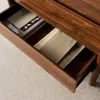 A close-up view of an open wooden drawer containing papers and other items. Anteprima dell’immagine prodotto
